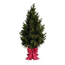 Pre-lit pine topiary with red bow and warm lights, full silhouette