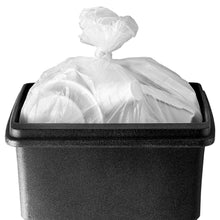 White plastic trash liner bag tied on dark trash can with lid