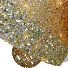 Gold glitter bell fabric detail with scattered sequins and warm light reflections