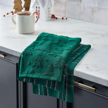 Teal-green holiday kitchen towel with stitched star/tree pattern and plaid trim, folded on counter