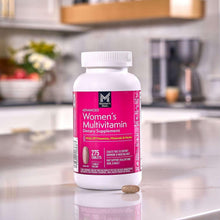 Women's multivitamin bottle with pink label, 275 tablets, with a loose tablet in view