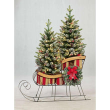 Pre-lit evergreen sleigh decoration with red bow, pine garland, and striped sled