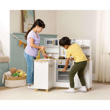 Kids kitchen playset with white cabinets, gold fixtures, oven door, and stove burners