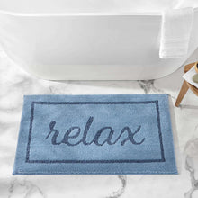 Blue bath mat with 'relax' text in dark lettering