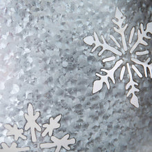 Galvanized metal tree collar close-up snowflake cutouts on galvanized surface