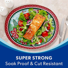 Oval holiday paper plate with ornament pattern holding salmon, greens, and vegetables