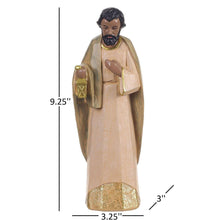 Nativity set king figurine standing with long robe, holding a small golden lantern.