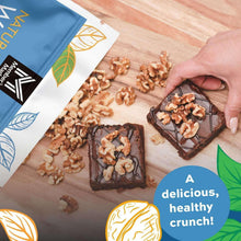 Walnuts bag beside brownies topped with chopped walnuts on a wooden surface.
