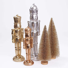 Nutcracker decor set: silver, gold, bronze nutcrackers with two mini pine trees