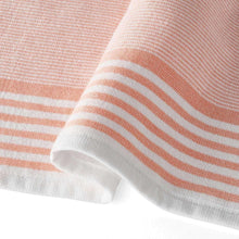 Warm peach and white kitchen towel with textured weave and striped border