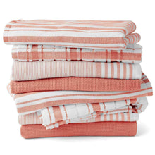 Stacked kitchen towels in warm peach and white with plaid and striped patterns