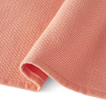 Warm peach kitchen towel with waffle-like texture and stitched hem