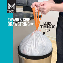 White tall kitchen trash bag cinched with orange expand-and-grip drawstring