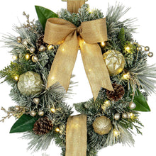 Pre-lit wreath door hanger close-up with tan bow, pine greenery, gold ornaments and pinecones