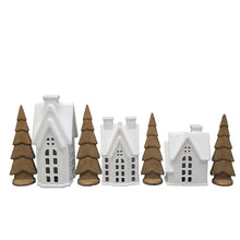 Pre-lit holiday village set with white buildings and brown pine trees