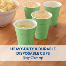 Green disposable cups filled with light beverage, set of multiple cups