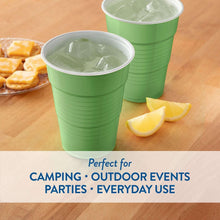 Green disposable cups with ice and lemon slices, with snack food nearby