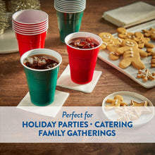 Red and green holiday party cups filled with drink, placed on table