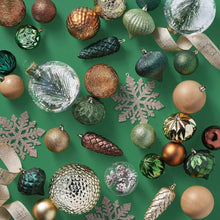 Assorted Christmas ornaments with green, bronze, and gold baubles and star and pinecone shapes