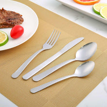 Stainless steel dinner forks set on a placemat, four tines visible