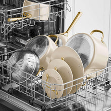 Cream ceramic cookware set in a dishwasher, with steamer inserts and lids