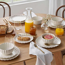 Scalloped dinnerware set in cream, with plates, bowls, and serving bowls for meals