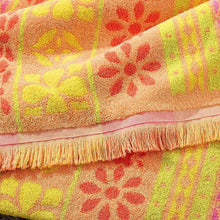 Close-up of fashion beach towel fringe edge with yellow, pink, and purple floral pattern