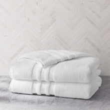 White bath sheet set with striped trim, two folded towels stacked