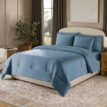 Blue comforter set with matching pillows and shams on a bed
