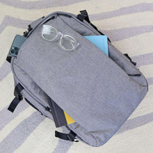 Gray backpack with side zipper opening showing inner mesh organizer and pockets