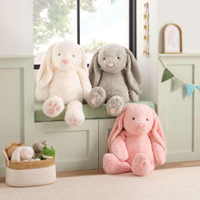 Assorted bunny plushes in white, gray, and pink on shelves and floor