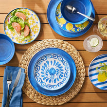 Round woven water hyacinth placemat with dark rim, centered beneath blue dishes.