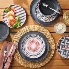 Round woven water hyacinth placemat with dark rim, centered under dinnerware.