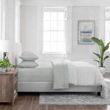 Light gray sheet set with pillowcases and fitted sheet on a bed