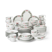 Porcelain holiday dinnerware set with bow and leaf pattern, stacked plates and mugs