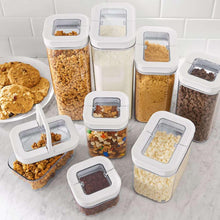 Clear flip-lock pantry storage containers with assorted dry ingredients, square lids
