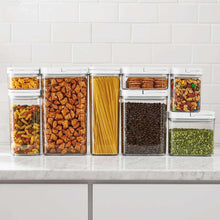 Set of clear pantry storage containers with flip-lock lids, filled with dry foods