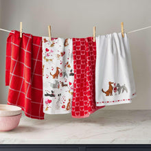 Kitchen towel set on a line: red plaid, hearts, and dog prints in white