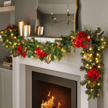 Pre-lit Christmas garland with pine greenery, red bows, and warm white lights