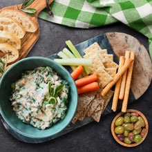 Plate with salmon dip and crackers, with carrot and celery sticks and olives