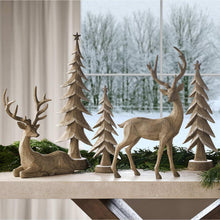 Deer and pine tree decor, including deer figures and star-topped tree ornaments