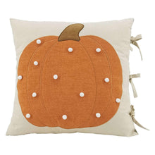 Decorative accent pillow with orange pumpkin applique and white dot stitching, beige cover
