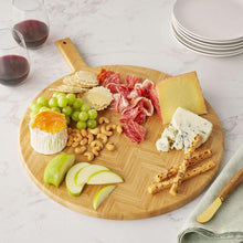 Bamboo charcuterie board with meats, cheeses, crackers, grapes, and fruit