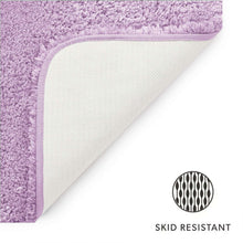 Wisteria bath rug with non-slip backing and stitched edge.