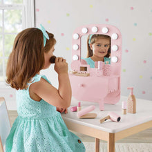 Pink kids tabletop vanity with round bulb mirror and makeup accessories on stand