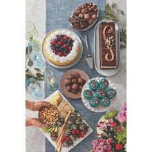 Milk chocolate almond pieces and assorted desserts on a serving spread