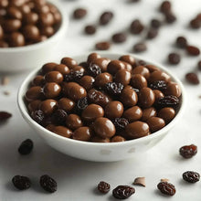 Bowl of milk chocolate raisins with glossy dark and tan chocolate pieces
