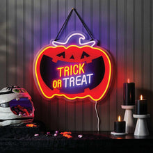 Neon pumpkin wall sign reading “Trick or Treat” with jack-o-lantern glow