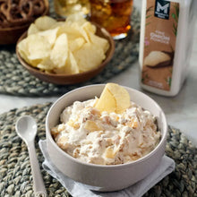 Creamy onion dip in a bowl with a spoon and onion chips