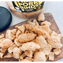 Bowl of fried pork rinds on a wooden board